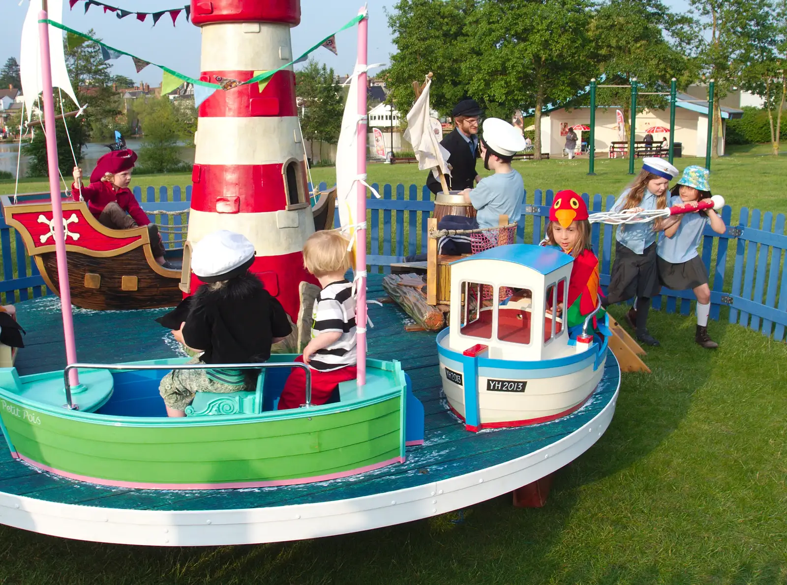 Some willing volunteers push the roundabout round, from A Family Fun Day on the Park, Diss, Norfolk - 16th May 2014