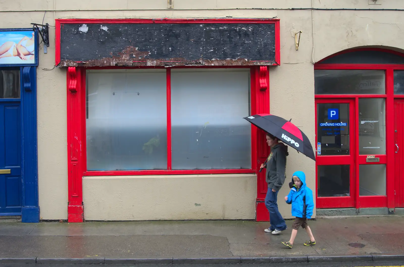 Isobel and Fred walk past an empty shop, from Camping at Silver Strand, Wicklow, County Wicklow, Ireland - 7th August 2014