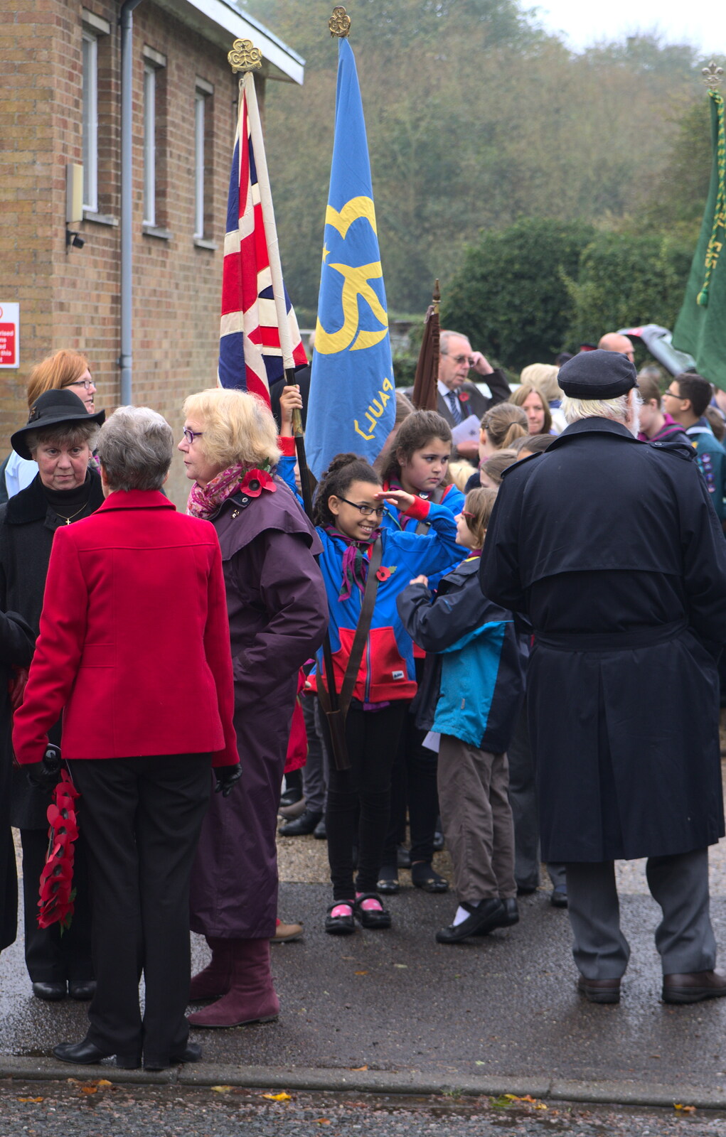 A flag-bearer gives a salute from A Remembrance Sunday Parade, Eye, Suffolk - 9th November 2014