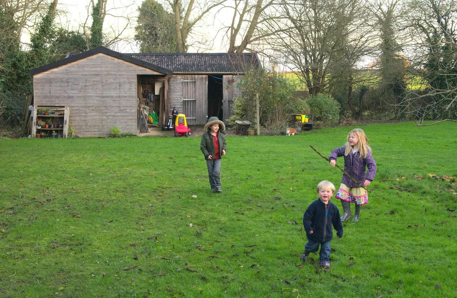 The children run around the garden with sticks, from Christmas Day at the Swan Inn, Brome, Suffolk - 25th December 2014