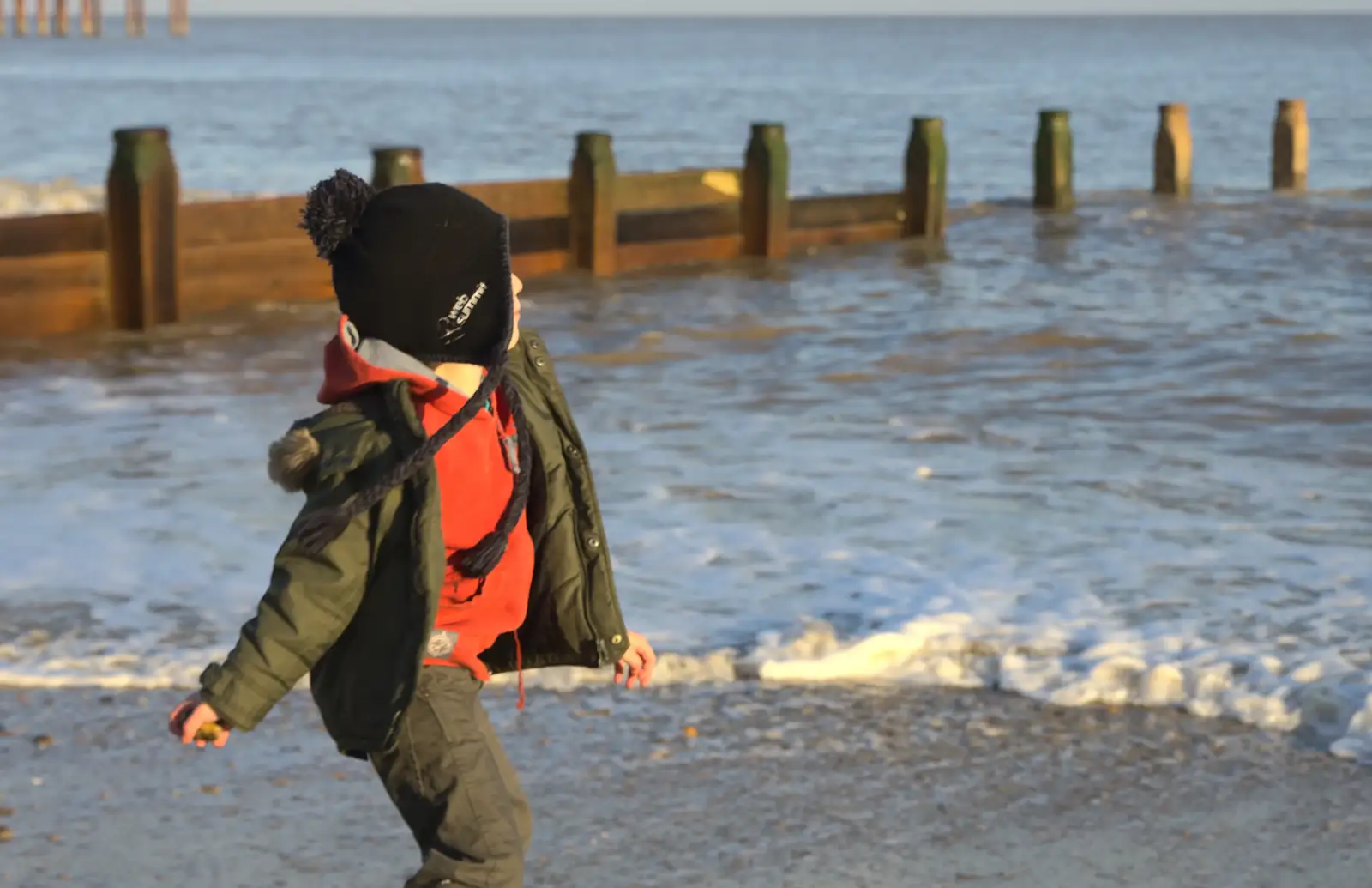 Fred hurls stones into the sea, from Sunset on the Beach, Southwold, Suffolk - 30th December 2014