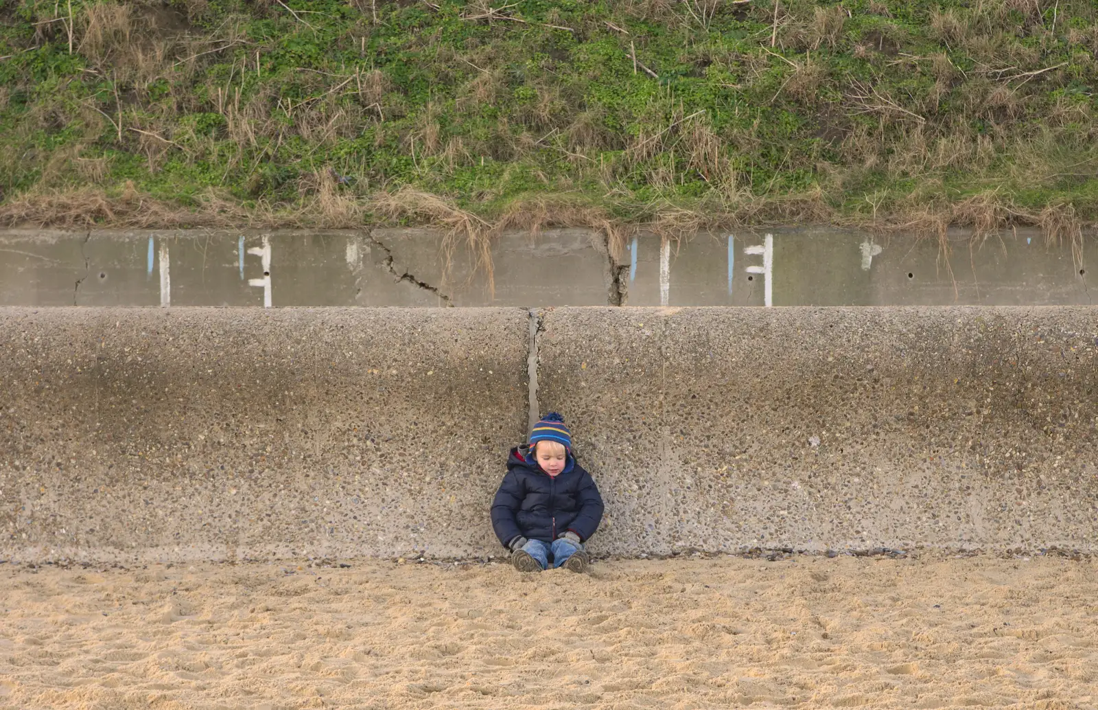 Harry sits against the sea wall, from Sunset on the Beach, Southwold, Suffolk - 30th December 2014