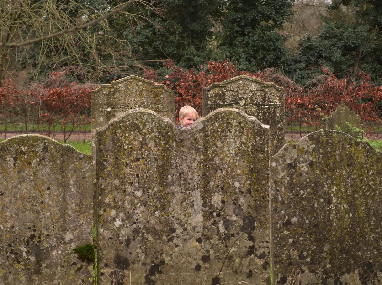 Harry peeks up from behind the gravestones, from New Year's Eve With The BBs, The Barrel, Banham, Norfolk - 31st December 2015