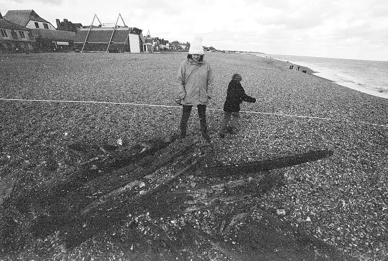 Isobel looks at a pile of logs, from Days on the Beach: Dunwich and Aldeburgh, Suffolk - 15th February 2016