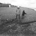 Isobel looks at a pile of logs, Days on the Beach: Dunwich and Aldeburgh, Suffolk - 15th February 2016