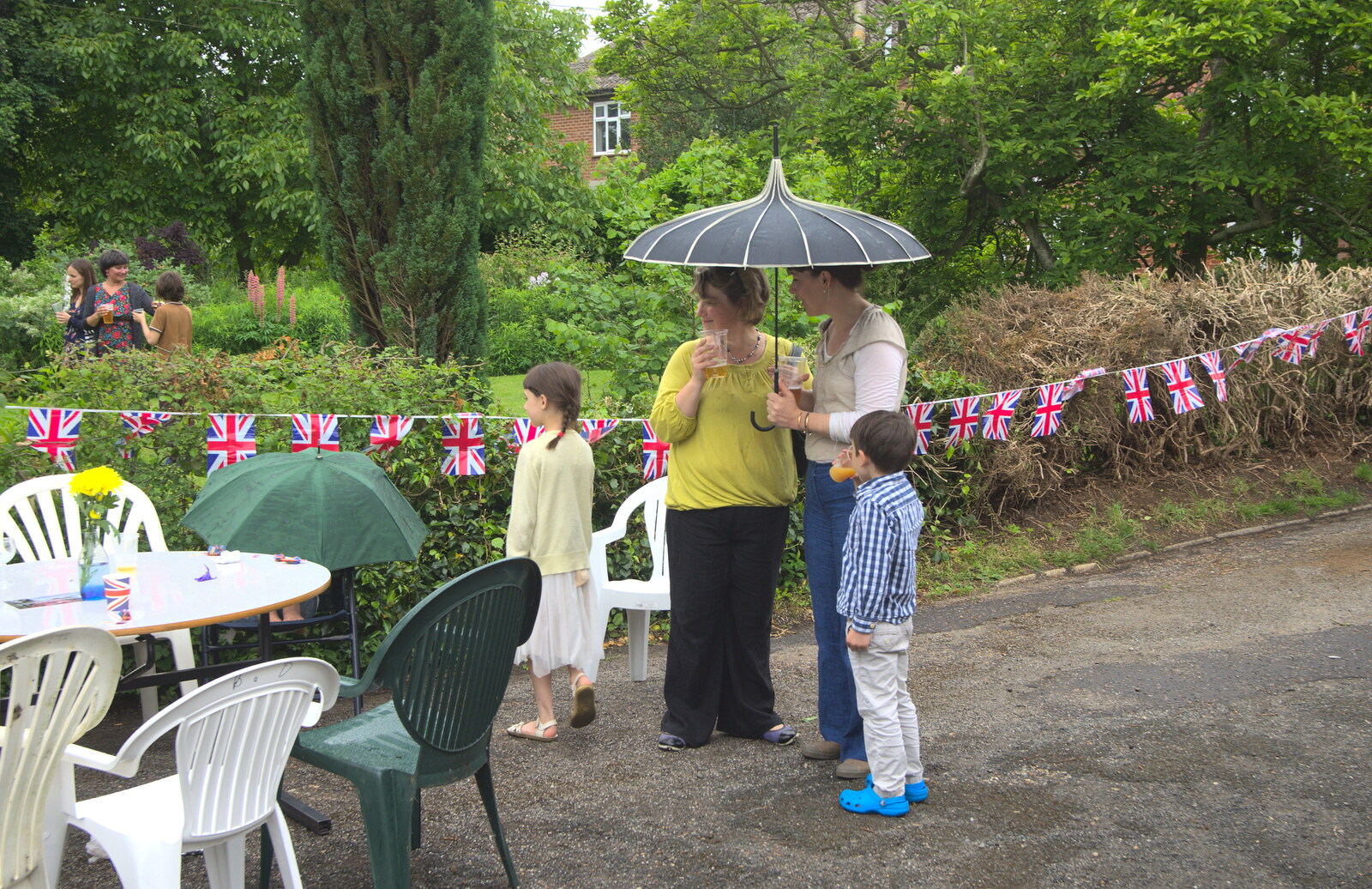 Outside, hardier guests shelter under an umbrella from The Queen's Village Hall Birthday, Brome, Suffolk - 12th June 2016