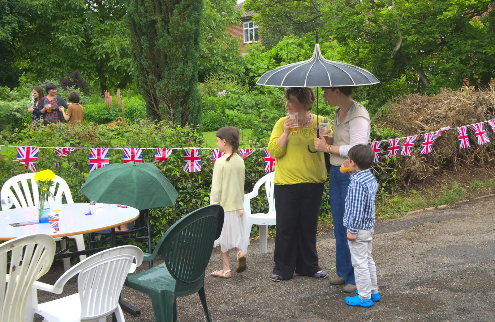 Outside, hardier guests shelter under an umbrella, from The Queen's Village Hall Birthday, Brome, Suffolk - 12th June 2016