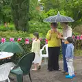 Outside, hardier guests shelter under an umbrella, The Queen's Village Hall Birthday, Brome, Suffolk - 12th June 2016