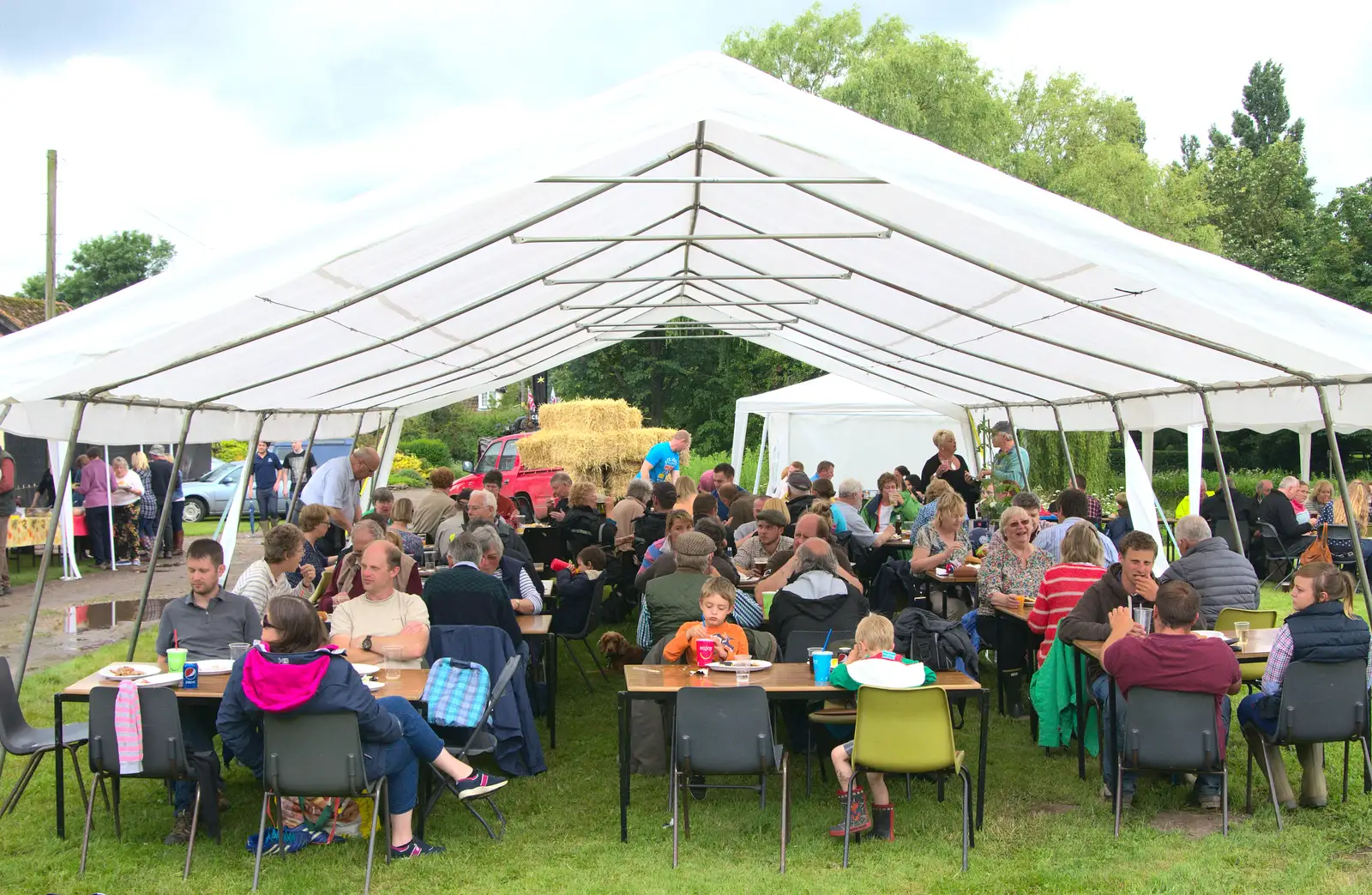 The crowd huddles under the marquee, from Thrandeston Pig, Little Green, Thrandeston, Suffolk - 26th June 2016