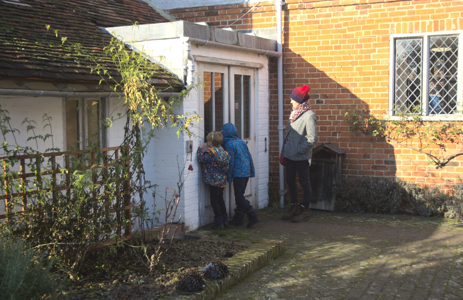 The boys peer into a door from A Day in Lavenham, Suffolk - 22nd January 2017