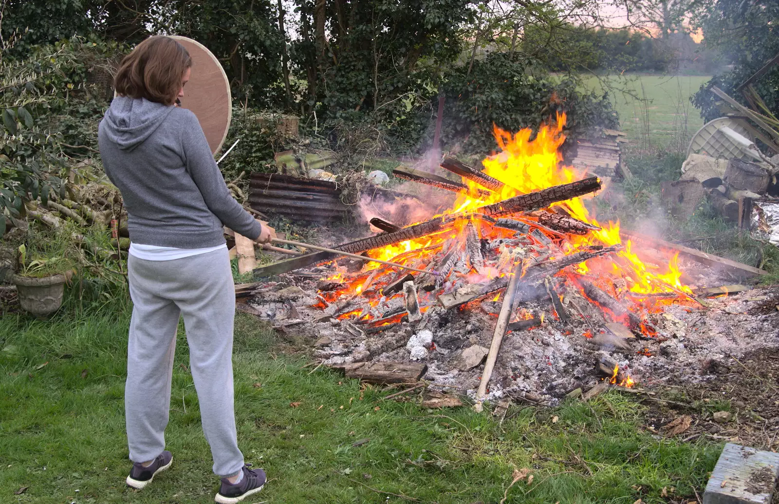 Isobel pokes a big bonfire with a stick, from A Postcard from Beccles, Suffolk - 2nd April 2017