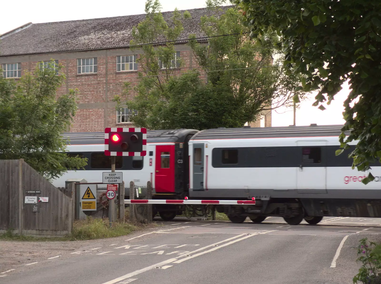 A train thunders through the crossing, from The BSCC at the Mellis Railway and The Swan, Brome, Suffolk - 8th June 2017