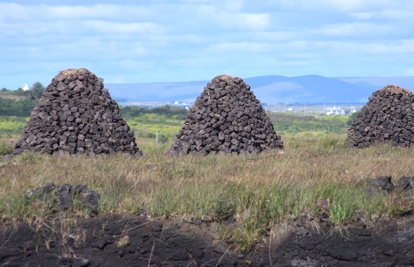 Three mounds of peat briquettes from Surfing Achill Island, Oileán Acla, Maigh Eo, Ireland - 8th August 2017