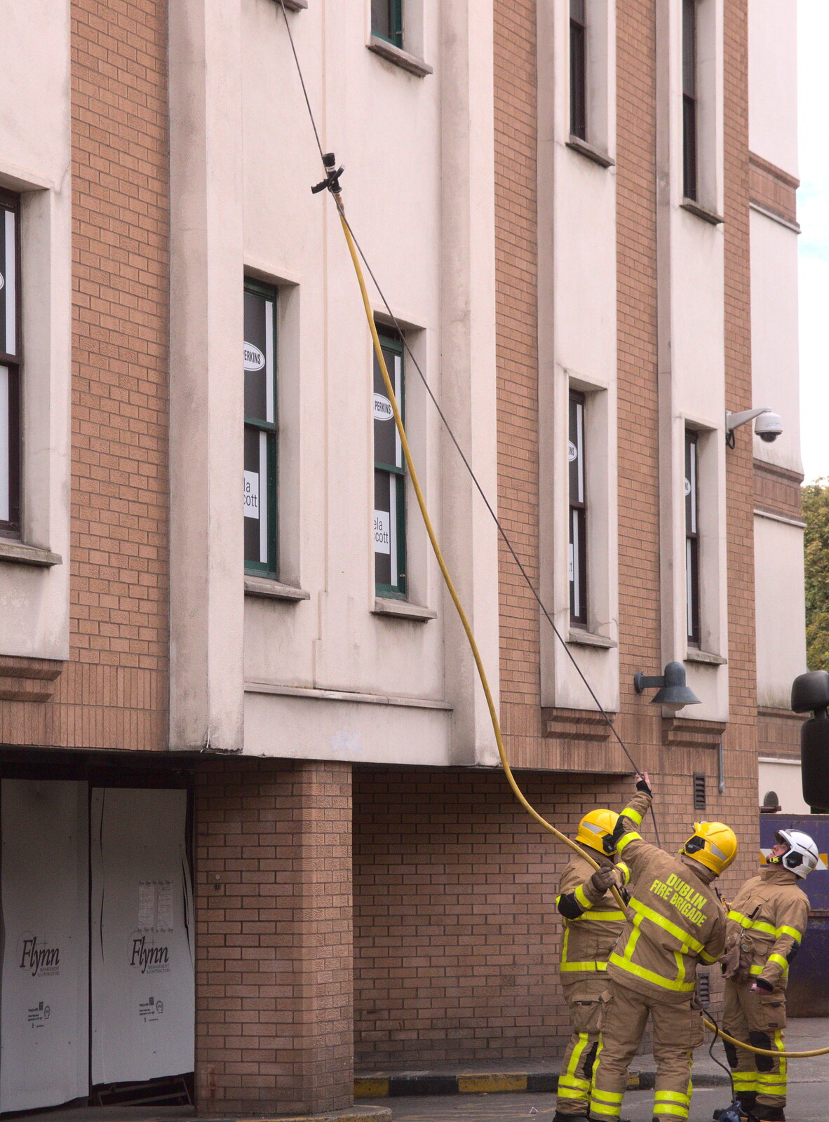 A hose is hauled up to an upstairs office from Fire and Water: The Burning of the Blackrock Centre, County Dublin, Ireland - 12th August 2017