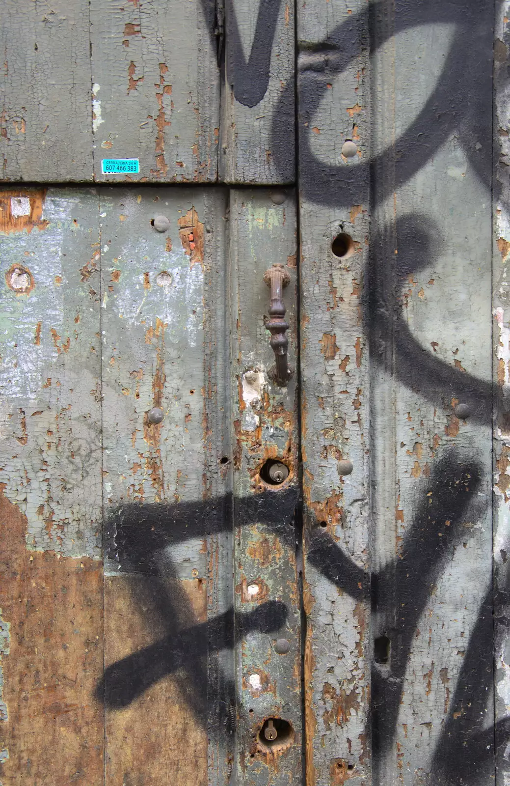 Graffiti and decaying paint on a door, from Barcelona and Parc Montjuïc, Catalonia, Spain - 21st October 2017