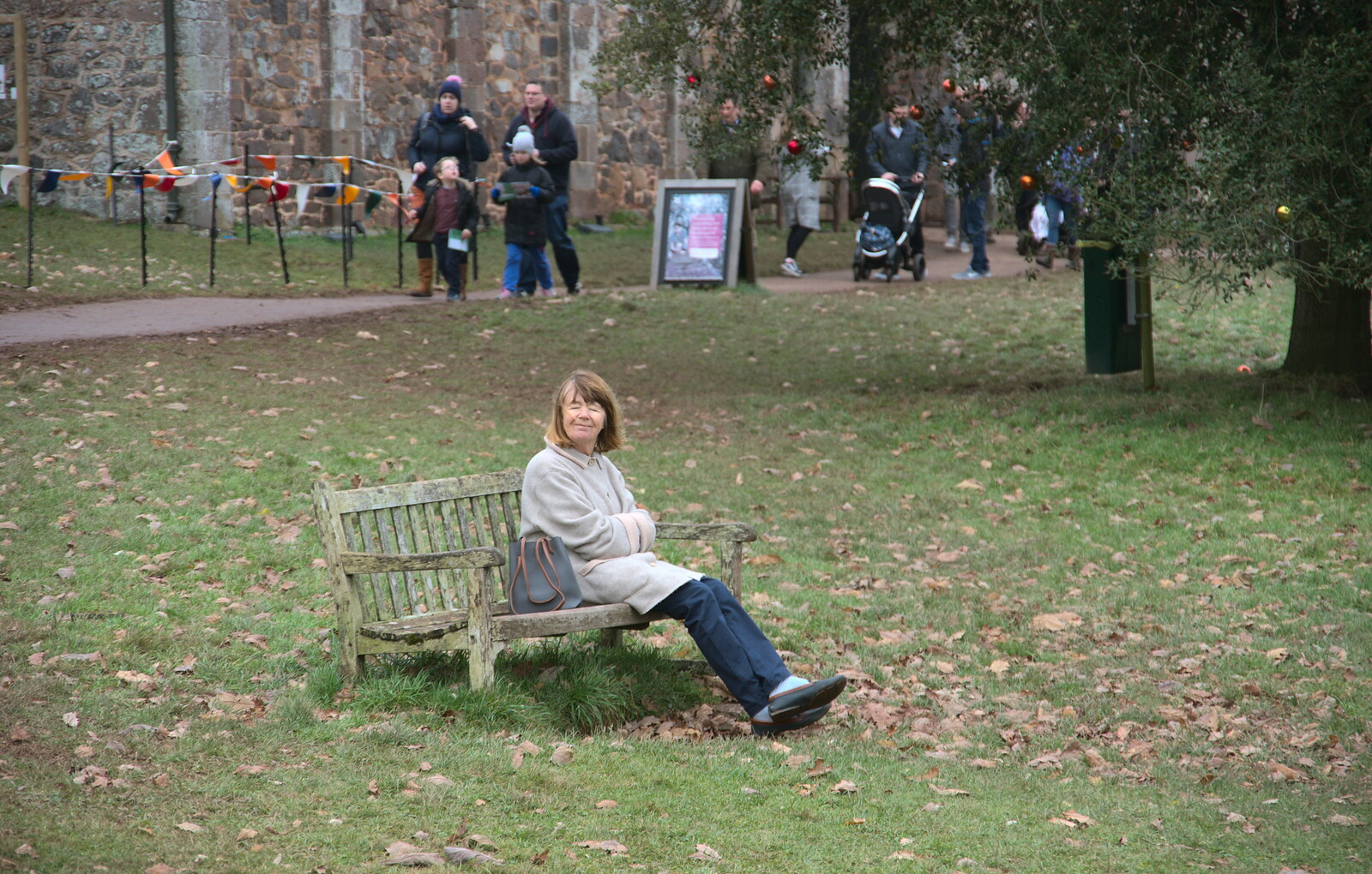 Mother sits on a bench from Killerton House, Broadclyst, Devon - 30th December 2017