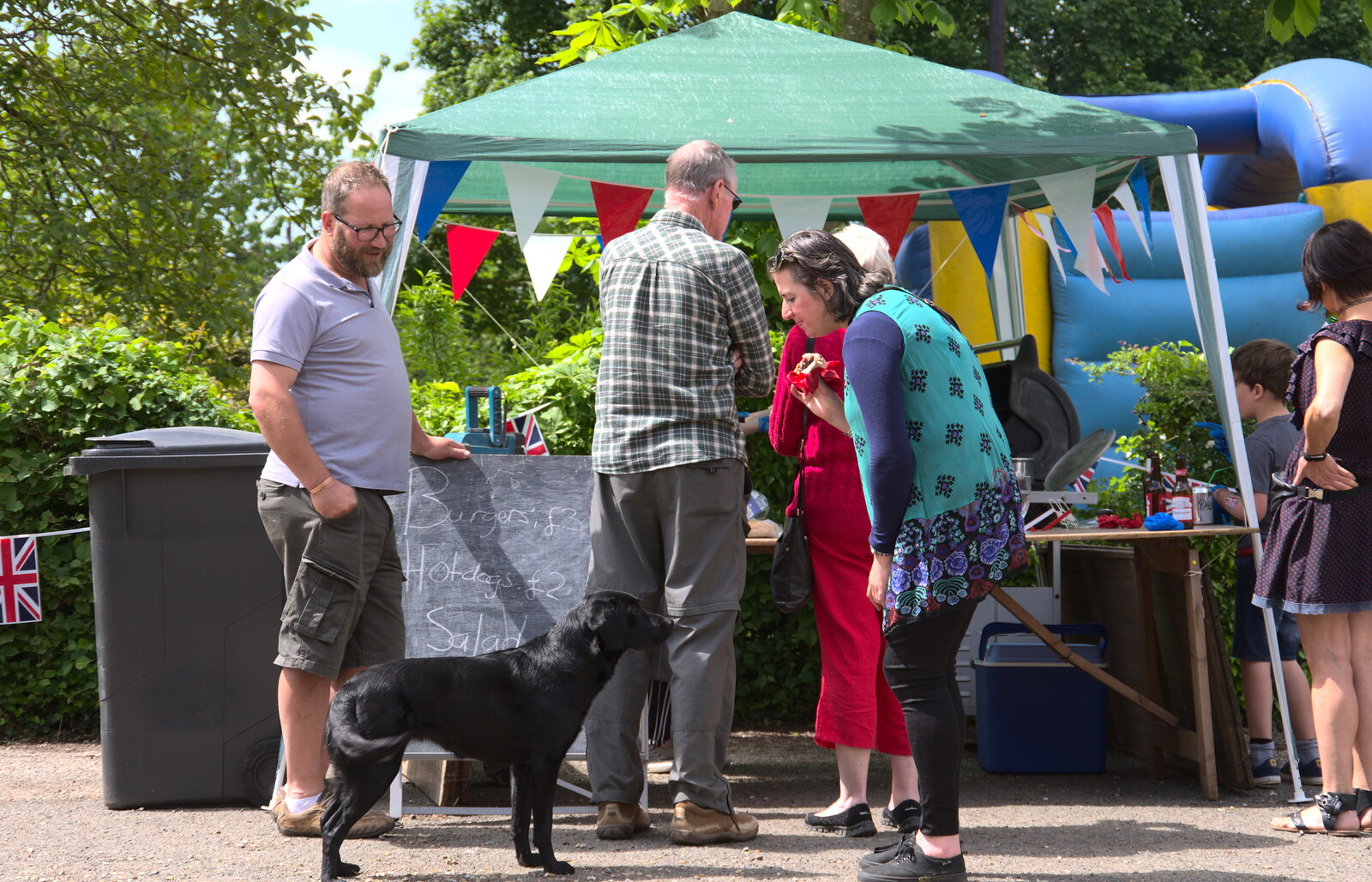 The dog roams around looking for more scraps from A Right Royal Wedding at the Village Hall, Brome, Suffolk - 19th May 2018