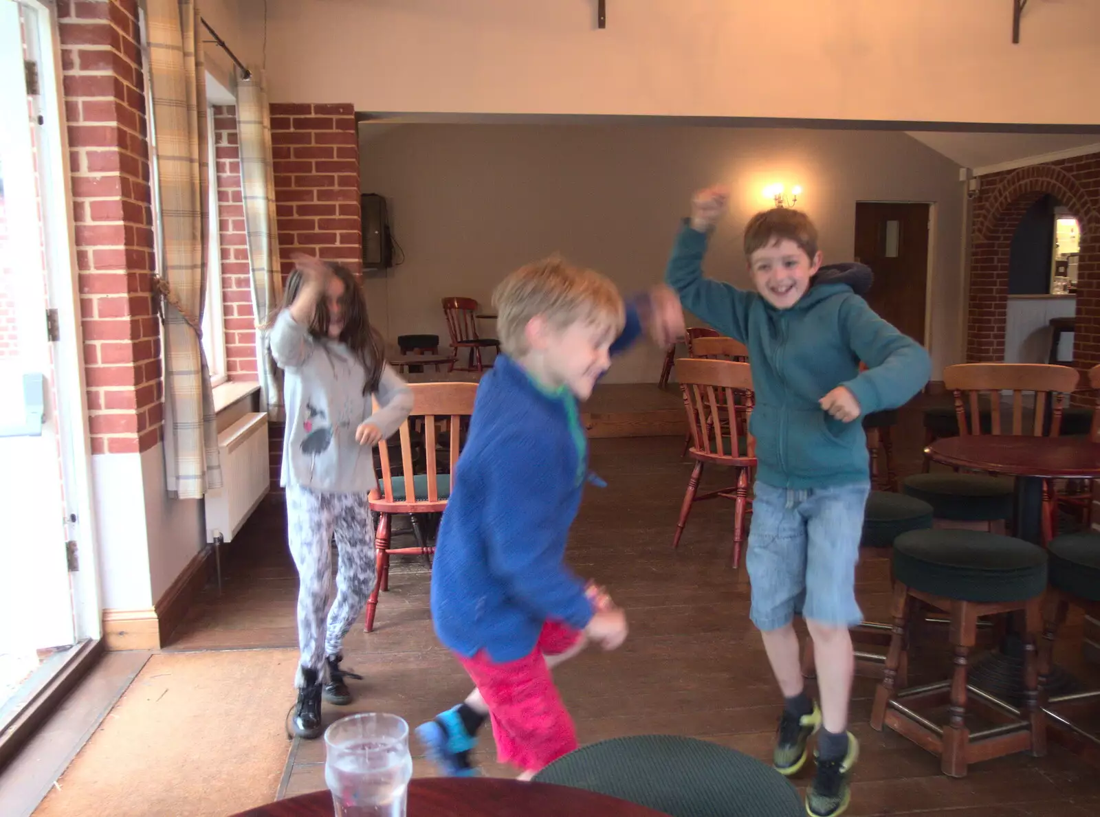 Isobel, Harry and Fred leap around in the clubhouse, from Dower House Camping, West Harling, Norfolk - 27th May 2018