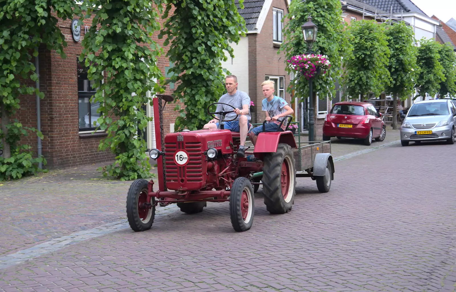 An Farmall D-217 tractor rumbles down Voorstraat, from A Postcard From Asperen, Gelderland, Netherlands - 9th June 2018