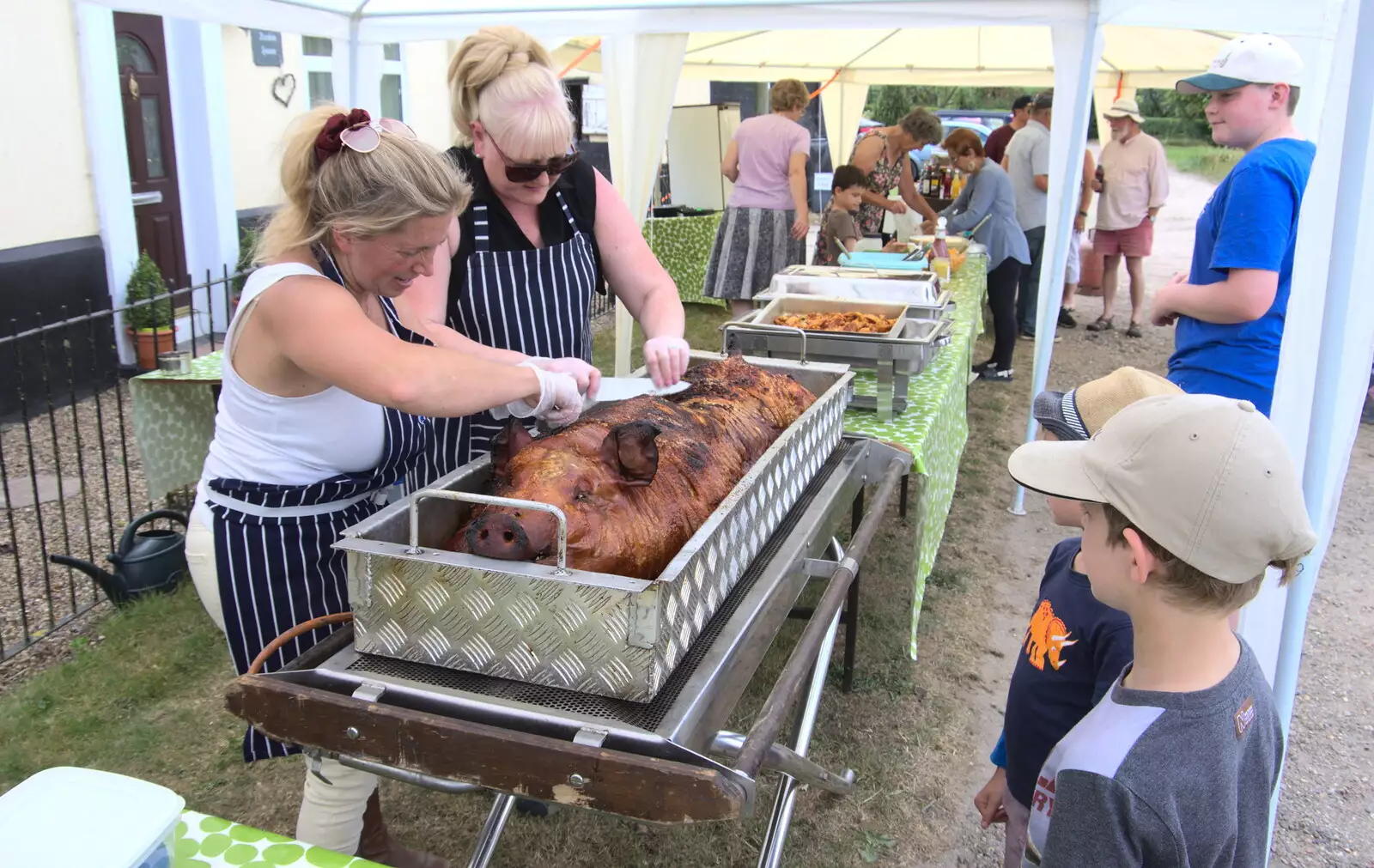 The boys watch as the hog is chopped up, from A Village Hog Roast, Little Green, Thrandeston, Suffolk - 24th June 2018