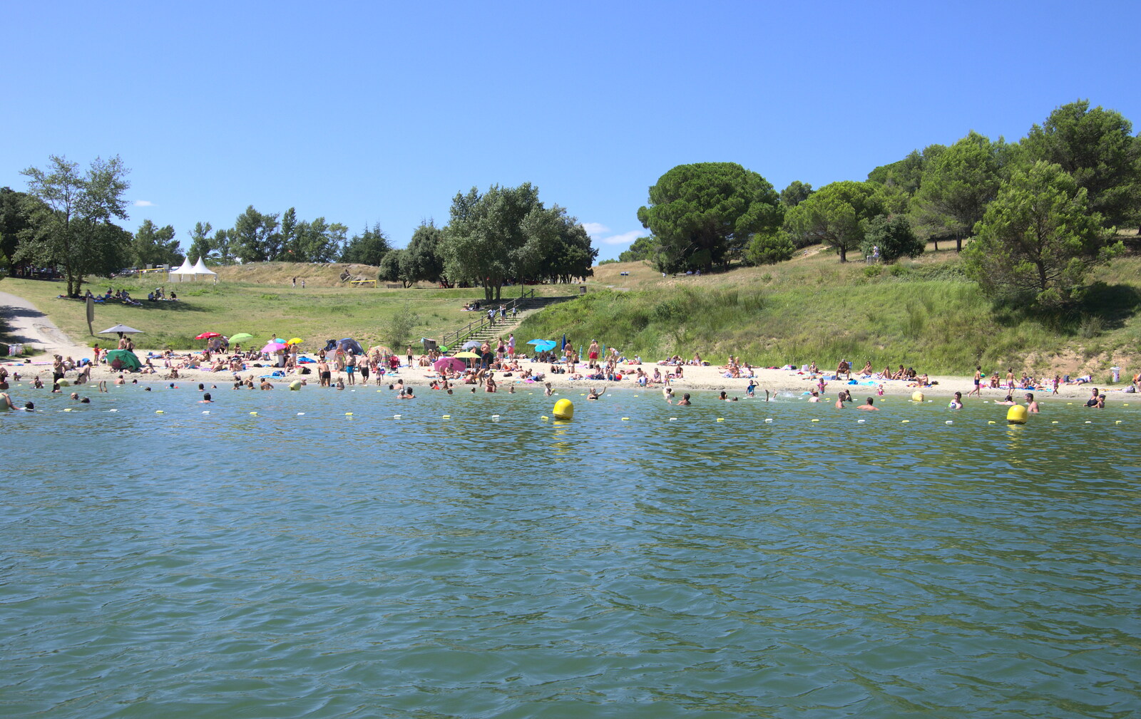The beach is now heaving, as seen from the pedalo from Abbaye Sainte-Marie de Lagrasse and The Lac de la Cavayère, Aude, France - 10th August