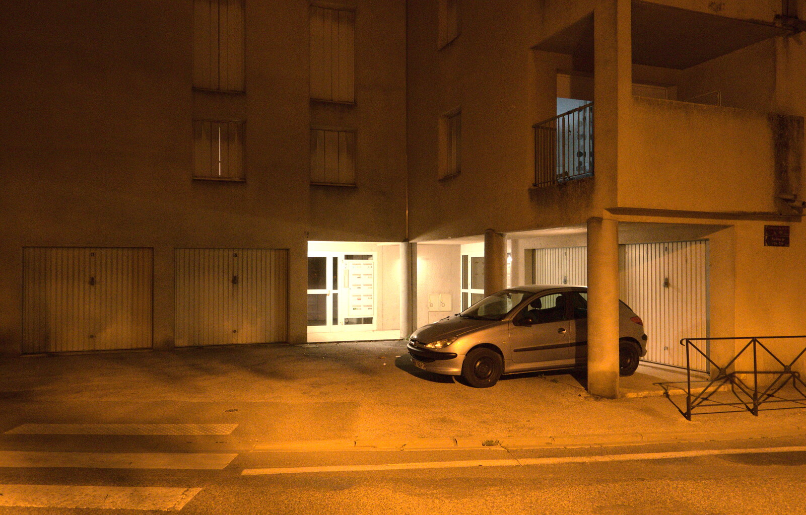 A solitary car waits at the bottom of an apartment block from Abbaye Sainte-Marie de Lagrasse and The Lac de la Cavayère, Aude, France - 10th August