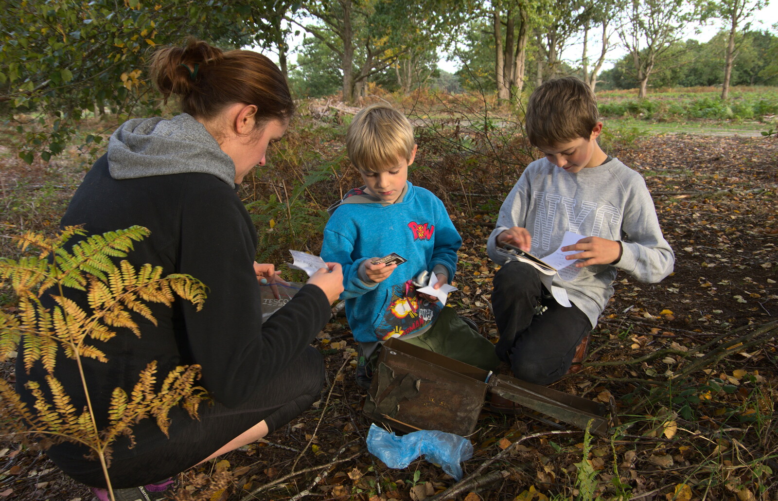 The gang inspect the contents of the geocache from Evidence of Autumn: Geocaching on Knettishall Heath, Suffolk - 7th October 2018