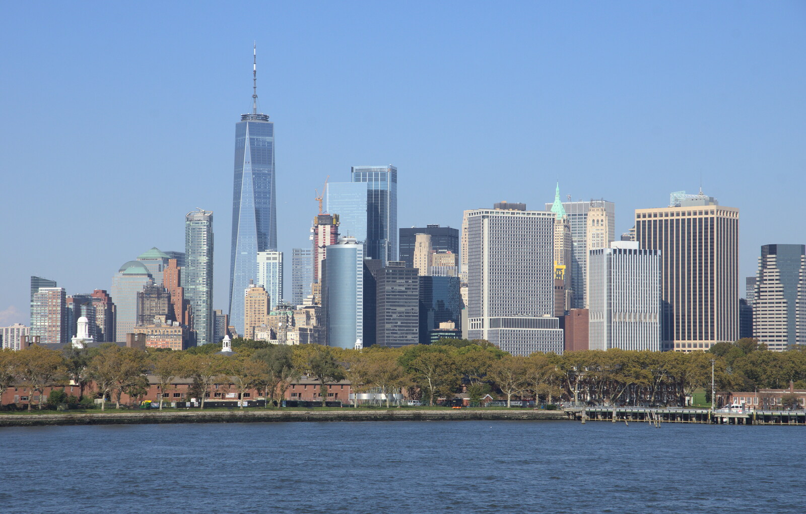 A view of NYC behind Governors' Island from The Liberty Cruise and One World Trade Center, New York, United States - 23rd October 2018
