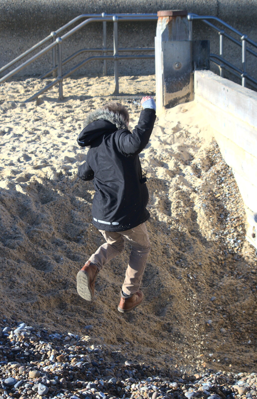 Fred jumps down into a hole on the beach from Sunset at the Beach, Southwold, Suffolk - 18th November 2018