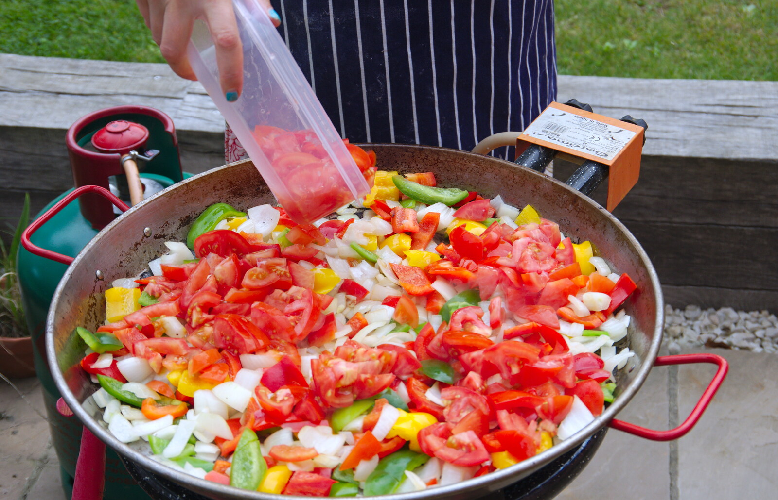 Isobel adds tomatoes to the paella from A Summer Party, Brome, Suffolk - 3rd August 2019