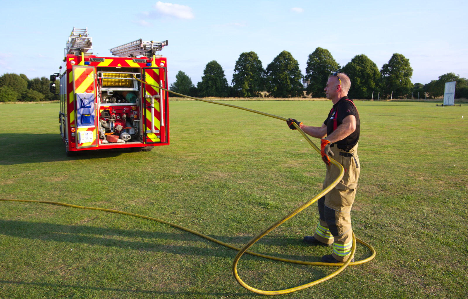 The crew unwind the hosepipe from A Water Fight with a Fire Engine, Eye Cricket Club, Suffolk - 5th August 2019