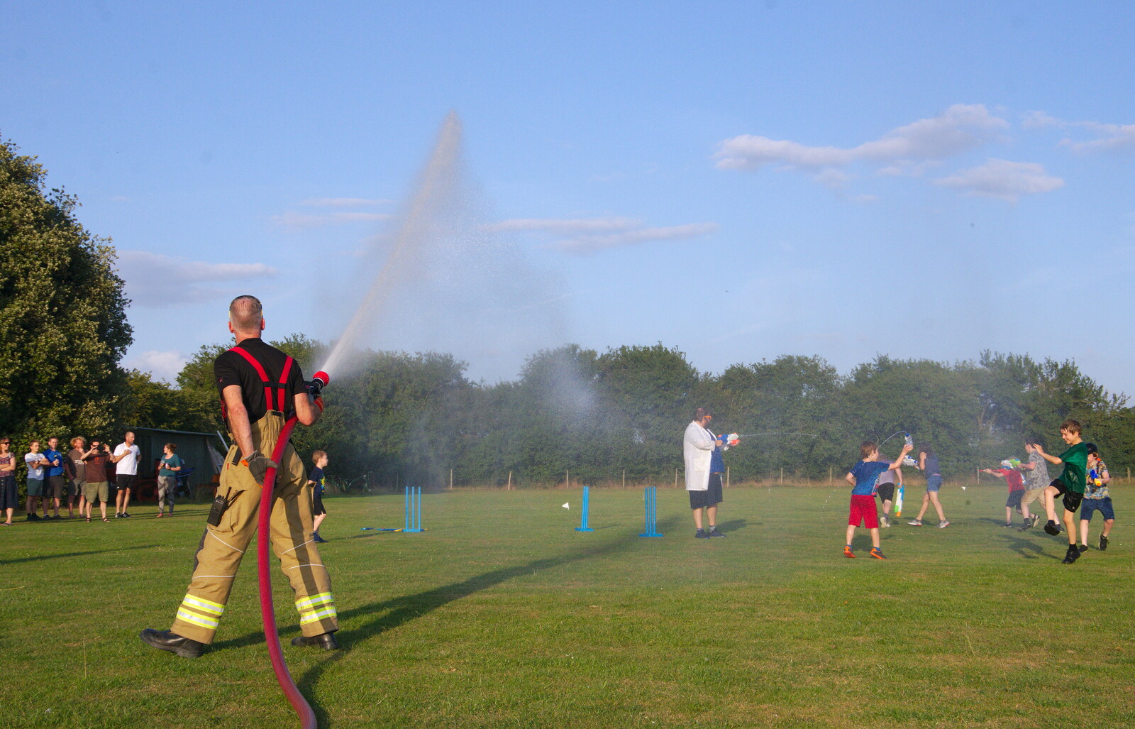 The fireman keeps the spraying going from A Water Fight with a Fire Engine, Eye Cricket Club, Suffolk - 5th August 2019