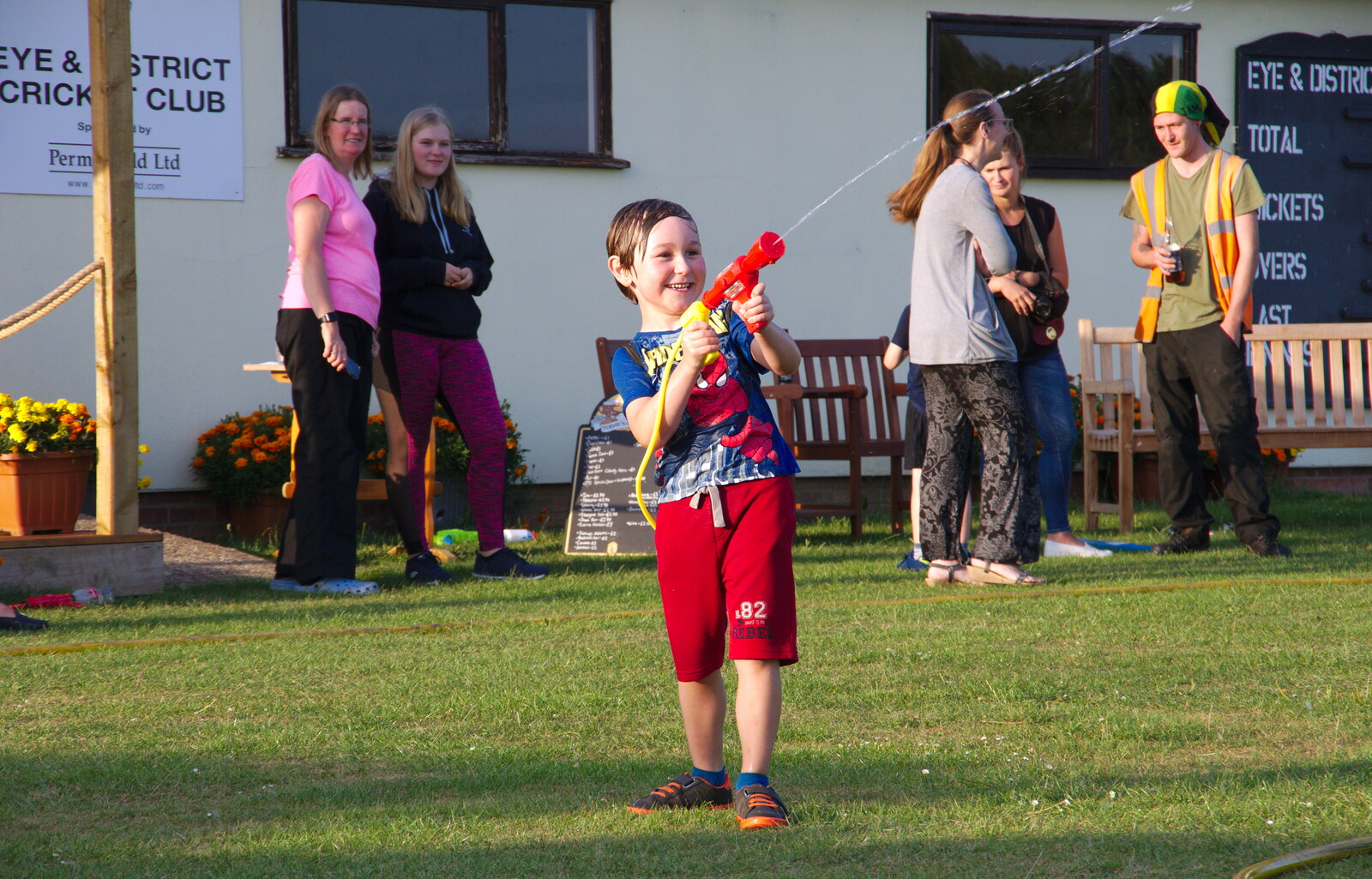 A boy gamely takes on the hose from A Water Fight with a Fire Engine, Eye Cricket Club, Suffolk - 5th August 2019