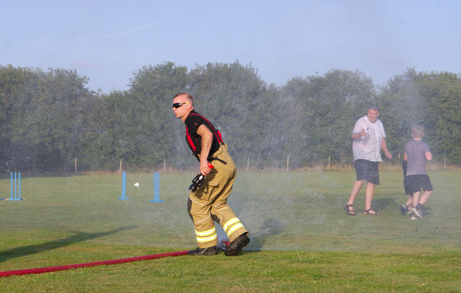 A fire-fighter sets up a wall of spray from A Water Fight with a Fire Engine, Eye Cricket Club, Suffolk - 5th August 2019