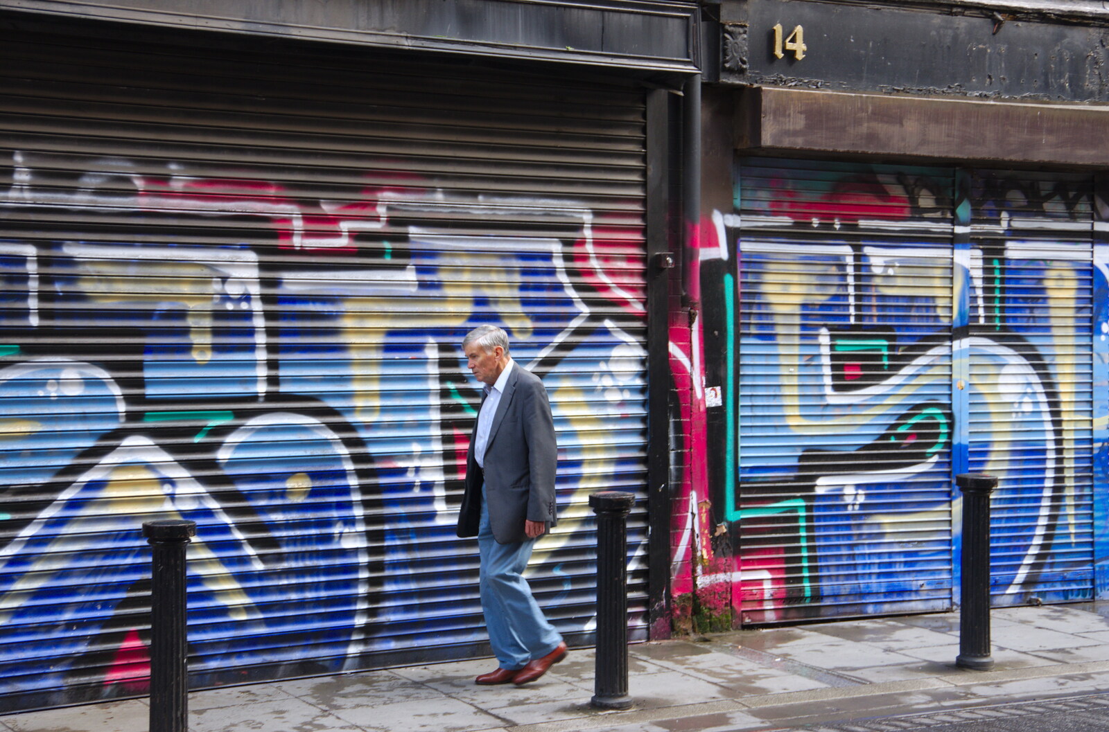 Some dude walks past graffiti shutters from Busking in Temple Bar, Dublin, Ireland - 12th August 2019
