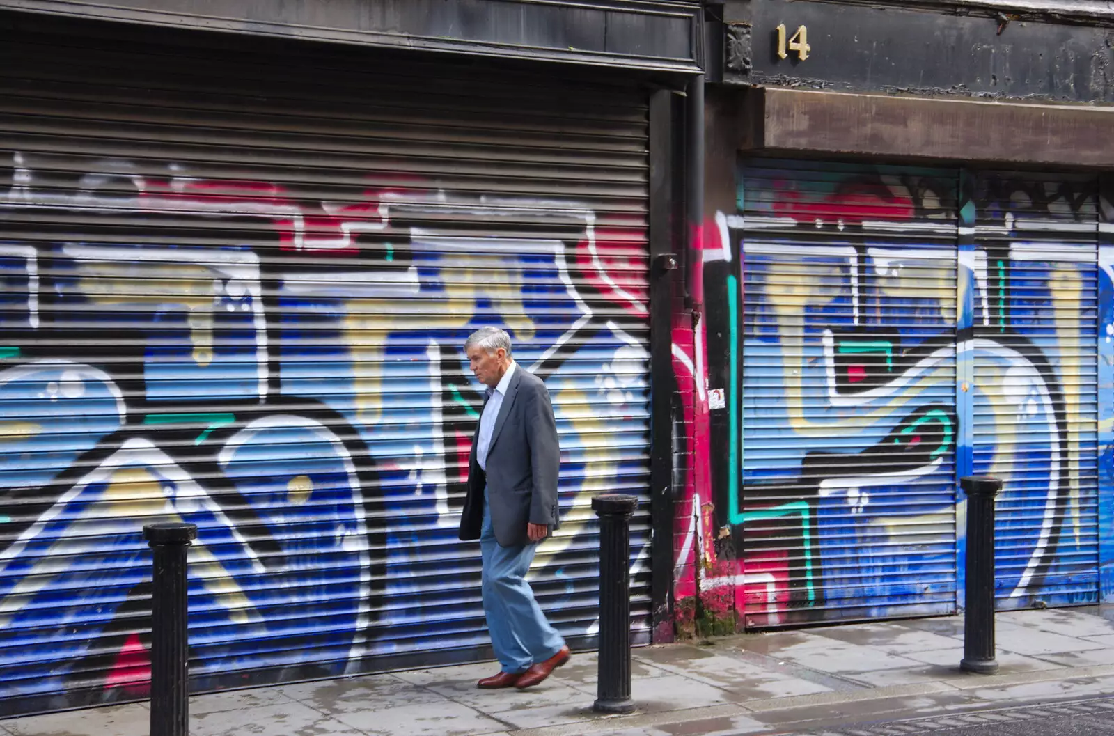 Some dude walks past graffiti shutters, from Busking in Temple Bar, Dublin, Ireland - 12th August 2019