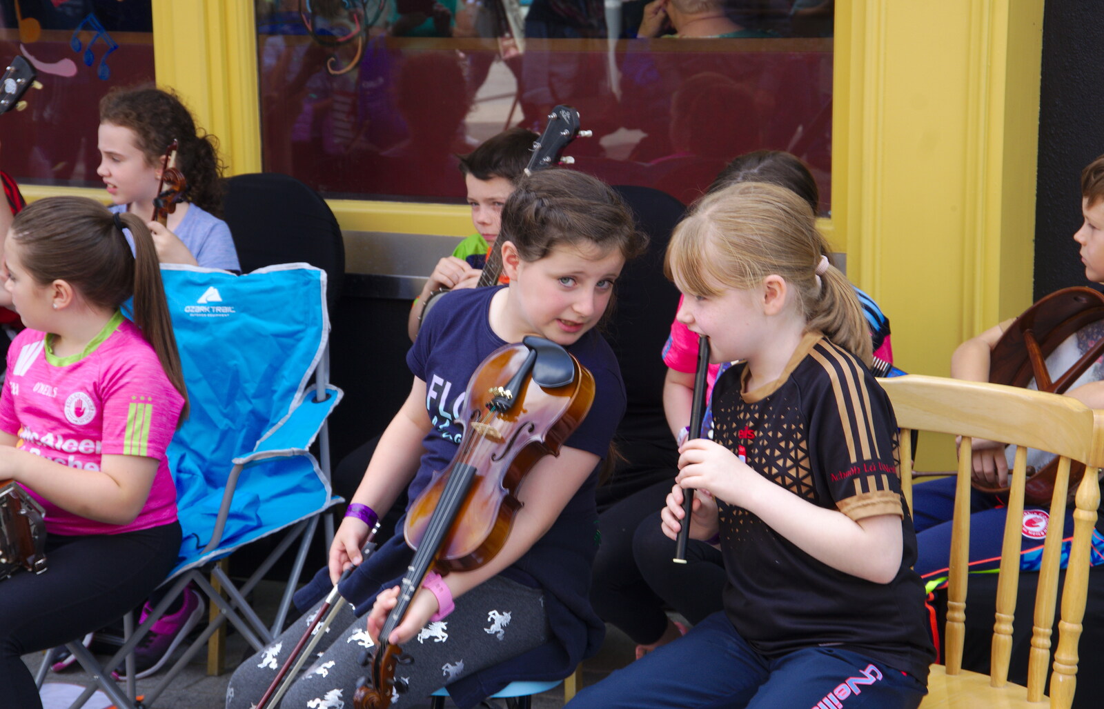A couple of girls swap musical tips from The Fleadh Cheoil na hÉireann, Droichead Átha, Co. Louth, Ireland - 13th August 2019