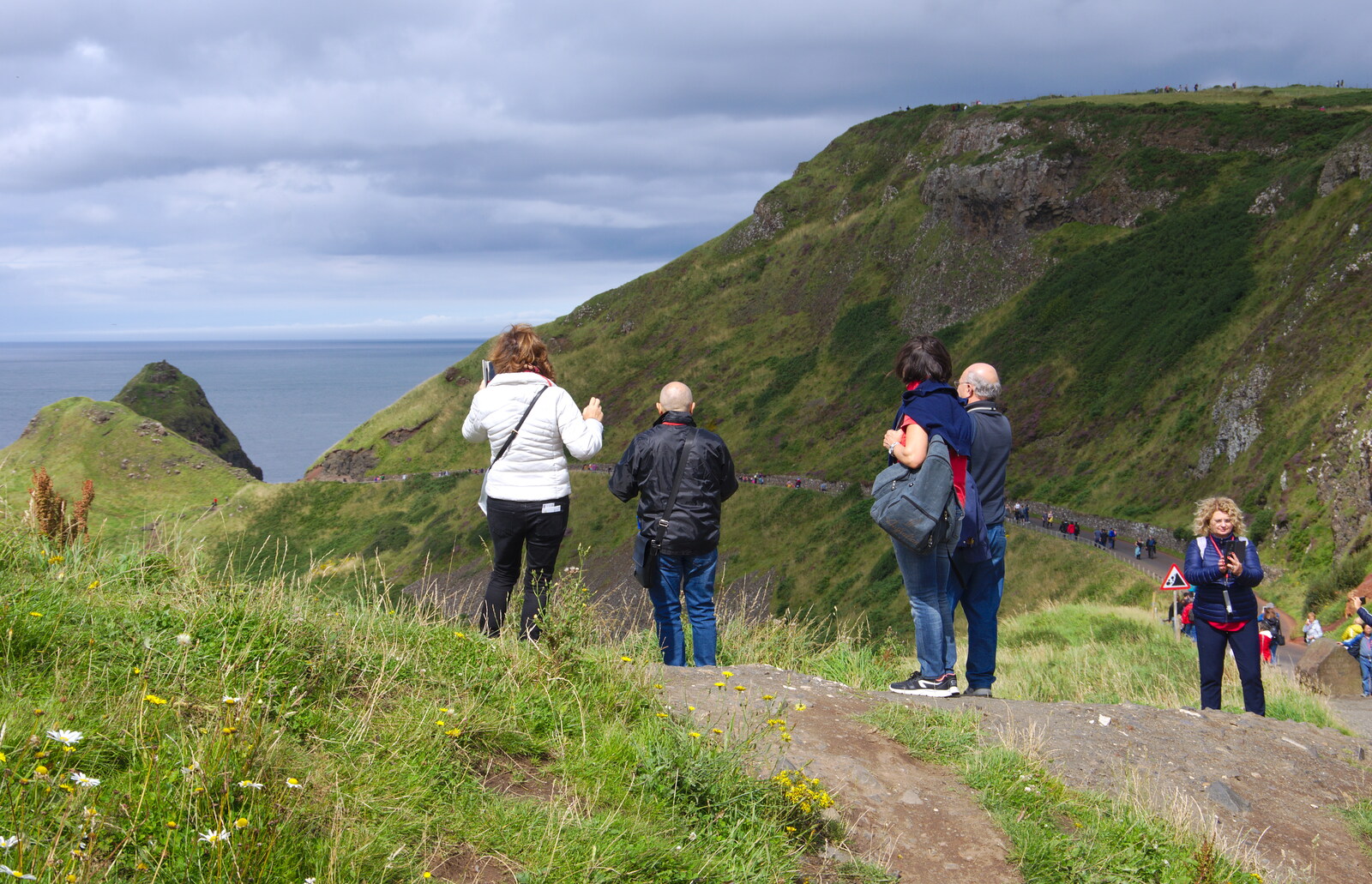 People at the top of a hill from The Giant's Causeway, Bushmills, County Antrim, Northern Ireland - 14th August 2019
