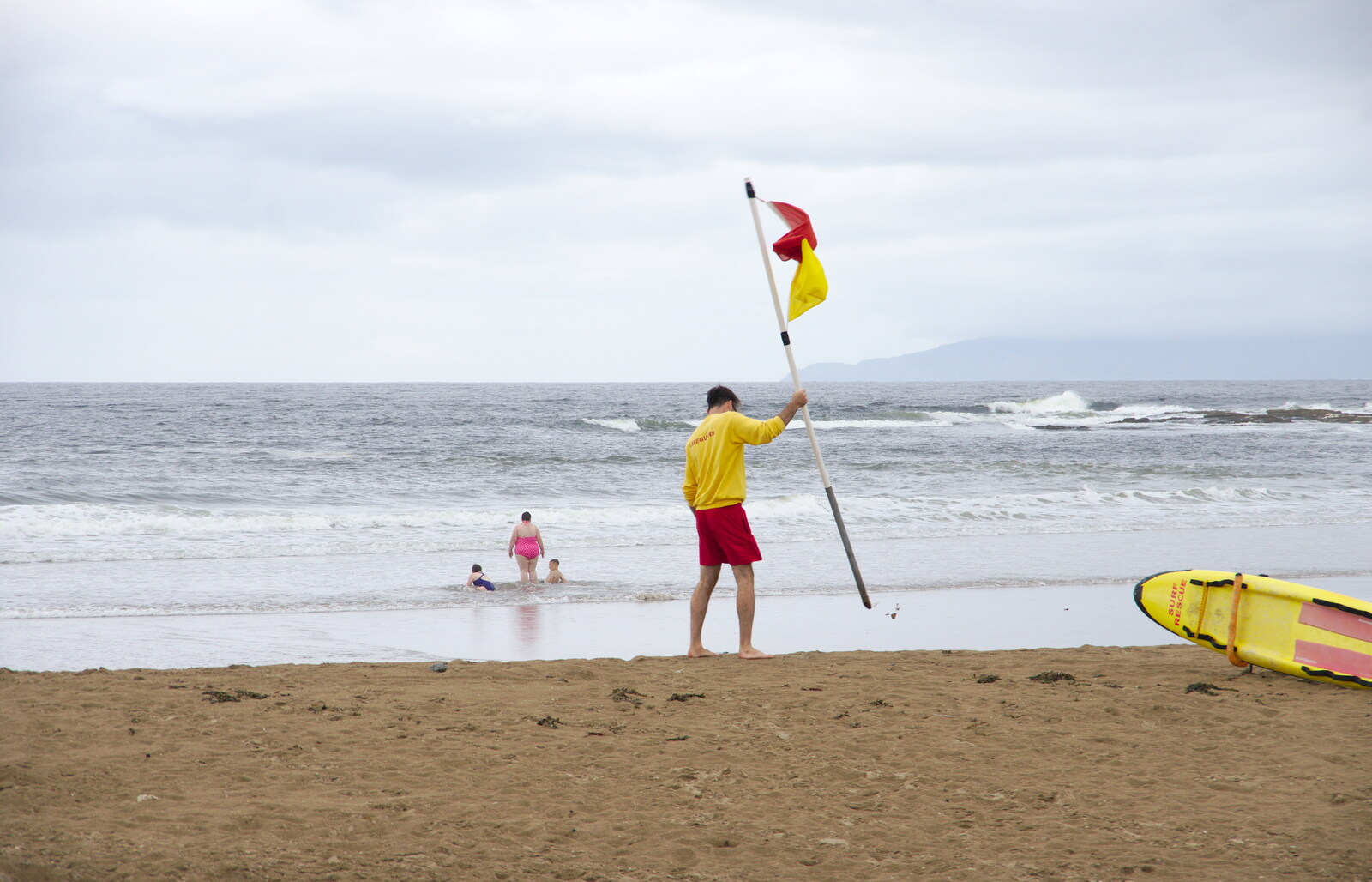 The lifeguard plants a flag from A Day in Derry, County Londonderry, Northern Ireland - 15th August 2019