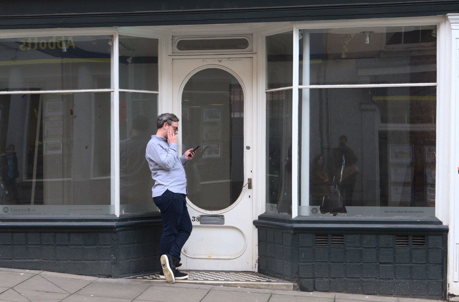 Some dude checks his phone outside an empty shop from A Trip to Cooke's Music, St. Benedict's Street, Norwich - 14th March 2020
