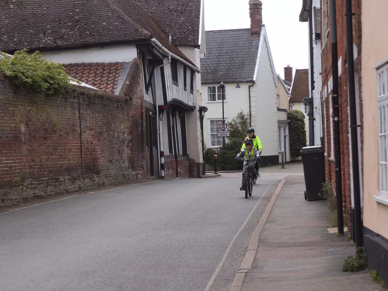 Harry and Isobel cycle up Church Street, from BSCC Beer Garden Hypothermia, Hoxne and Brome, Suffolk - 22nd April 2021