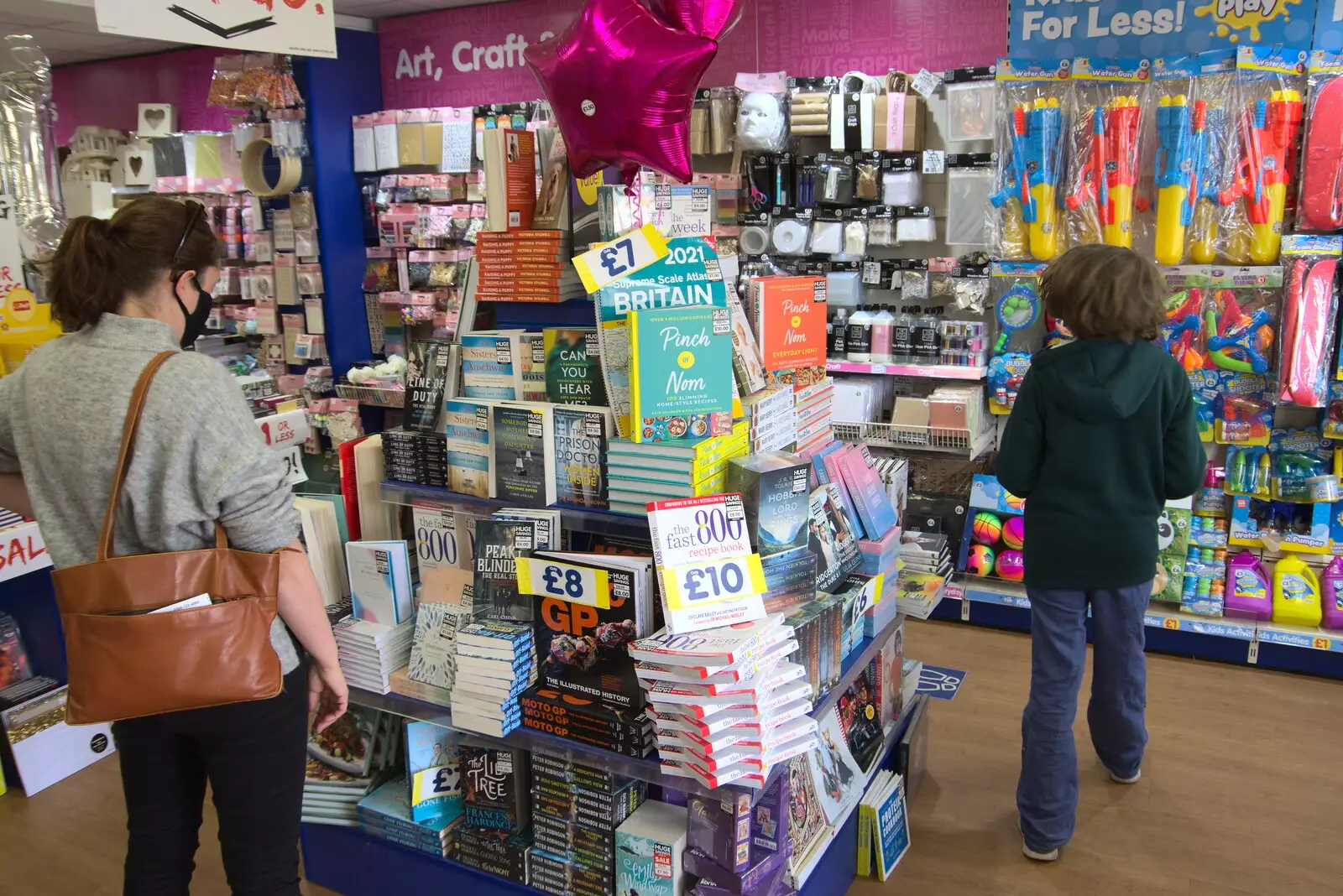 Isobel looks at a pile of books, from A Vaccination Afternoon, Swaffham, Norfolk - 9th May 2021