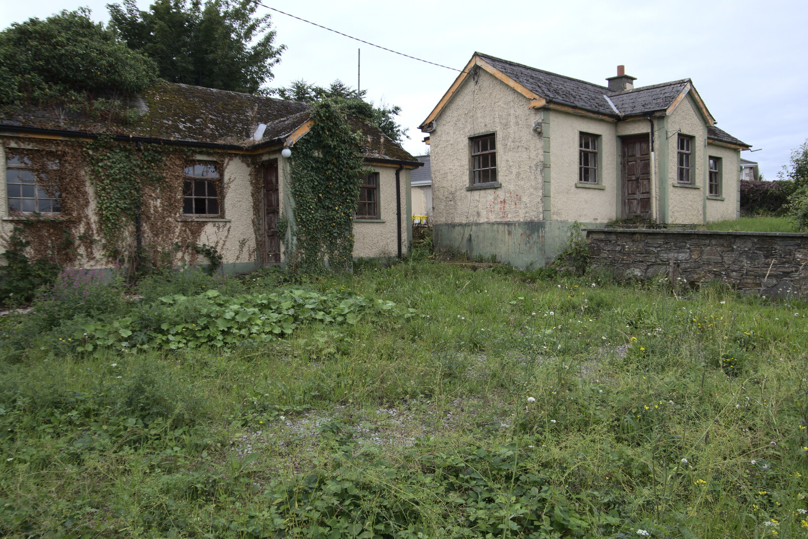 A Trip to Manorhamilton, County Leitrim, Ireland - 11th August 2021: Derelict buildings covered in weeds