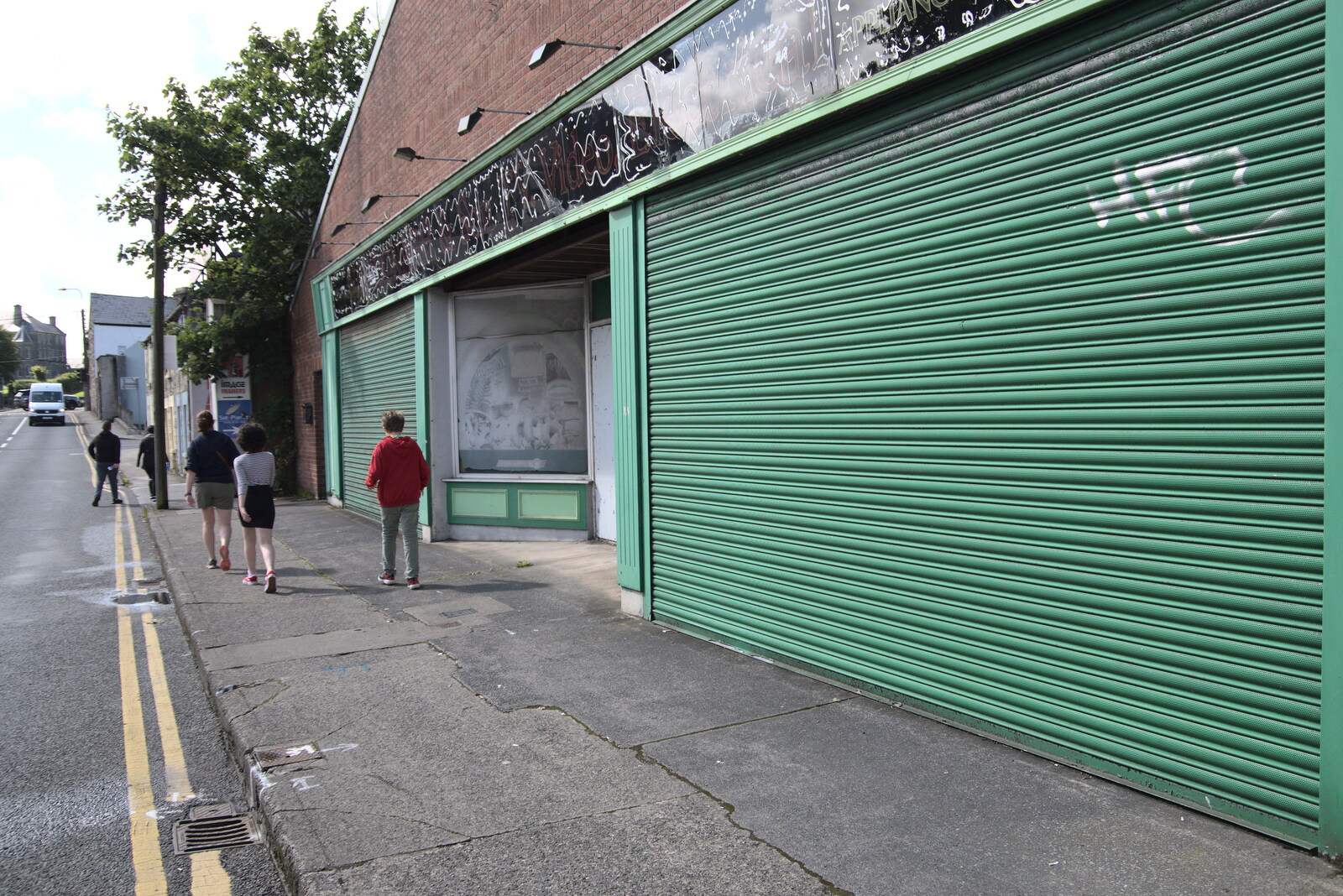 A Trip to Manorhamilton, County Leitrim, Ireland - 11th August 2021: Green shutters on a closed-down shop