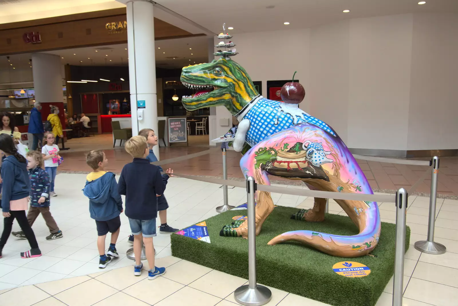 A dino with cakes on its head in Chapelfield, from Dippy and the City Dinosaur Trail, Norwich, Norfolk - 19th August 2021