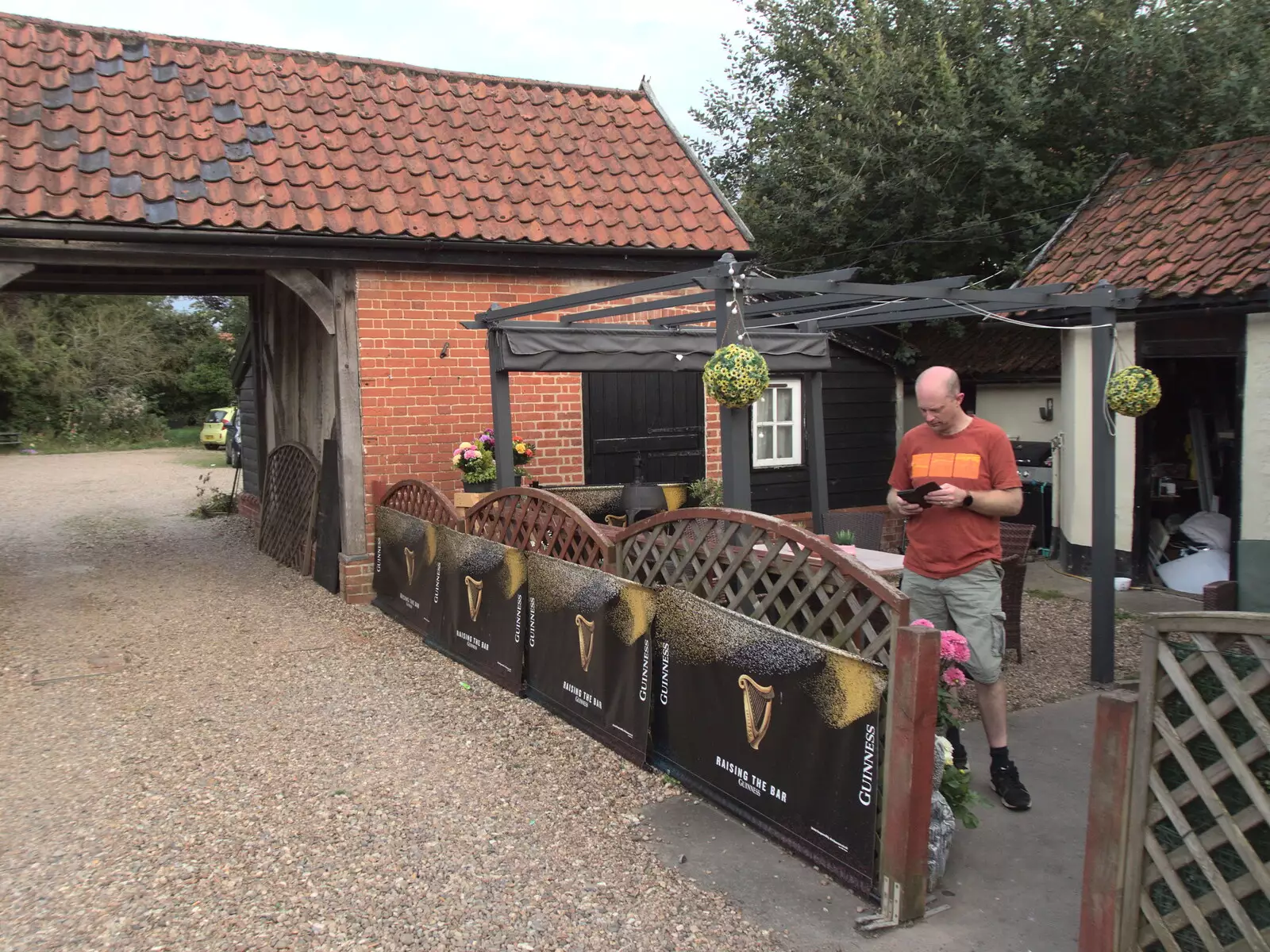 Paul checks his phone in the beer garden, from The BSCC at The Crown, Dickleburgh, Norfolk - 19th August 2021