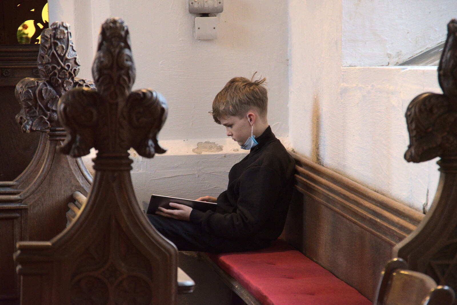 Harry sits in the choir and plays on a tablet from GSB Carols and Beer With the Lads, Thornham and Thorndon, Suffolk  - 18th December 2021