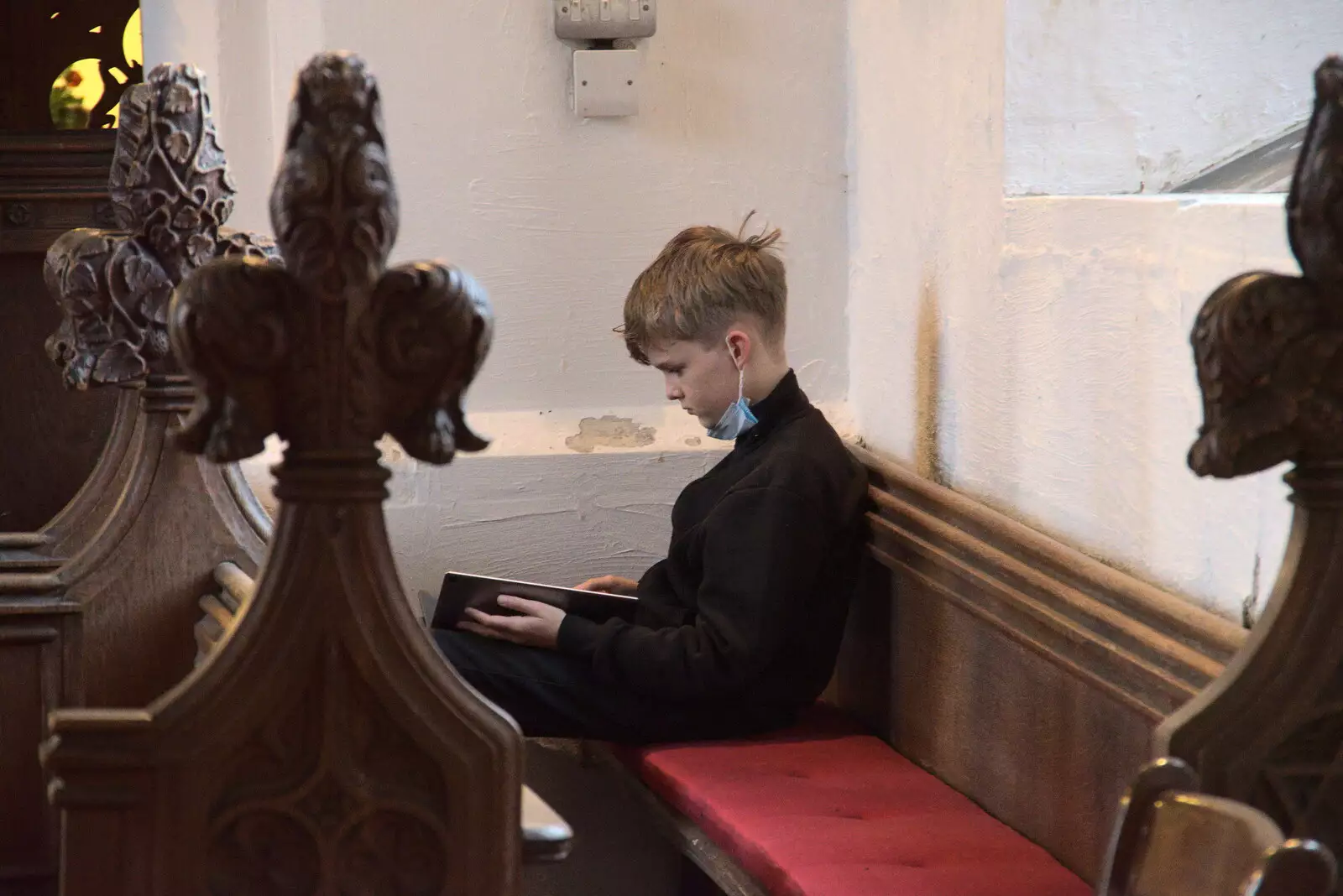 Harry sits in the choir and plays on a tablet, from GSB Carols and Beer With the Lads, Thornham and Thorndon, Suffolk  - 18th December 2021