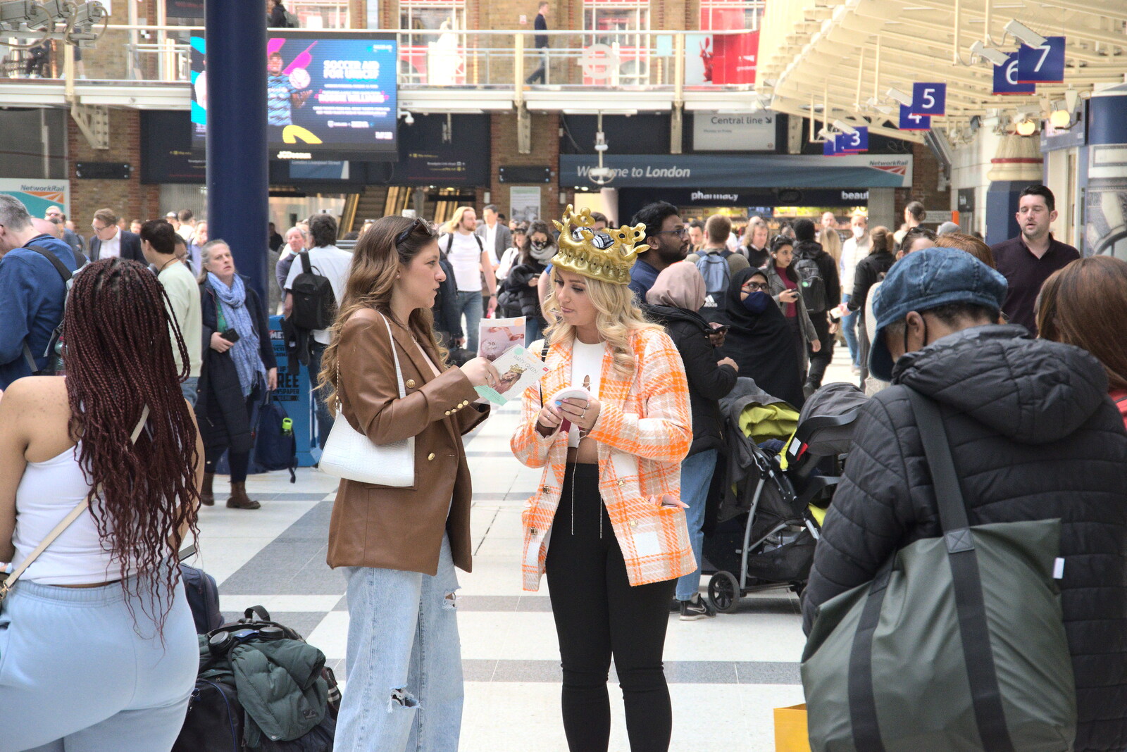 A Walk Around the South Bank, London - 25th March 2022: A woman with a crown checks a timetable