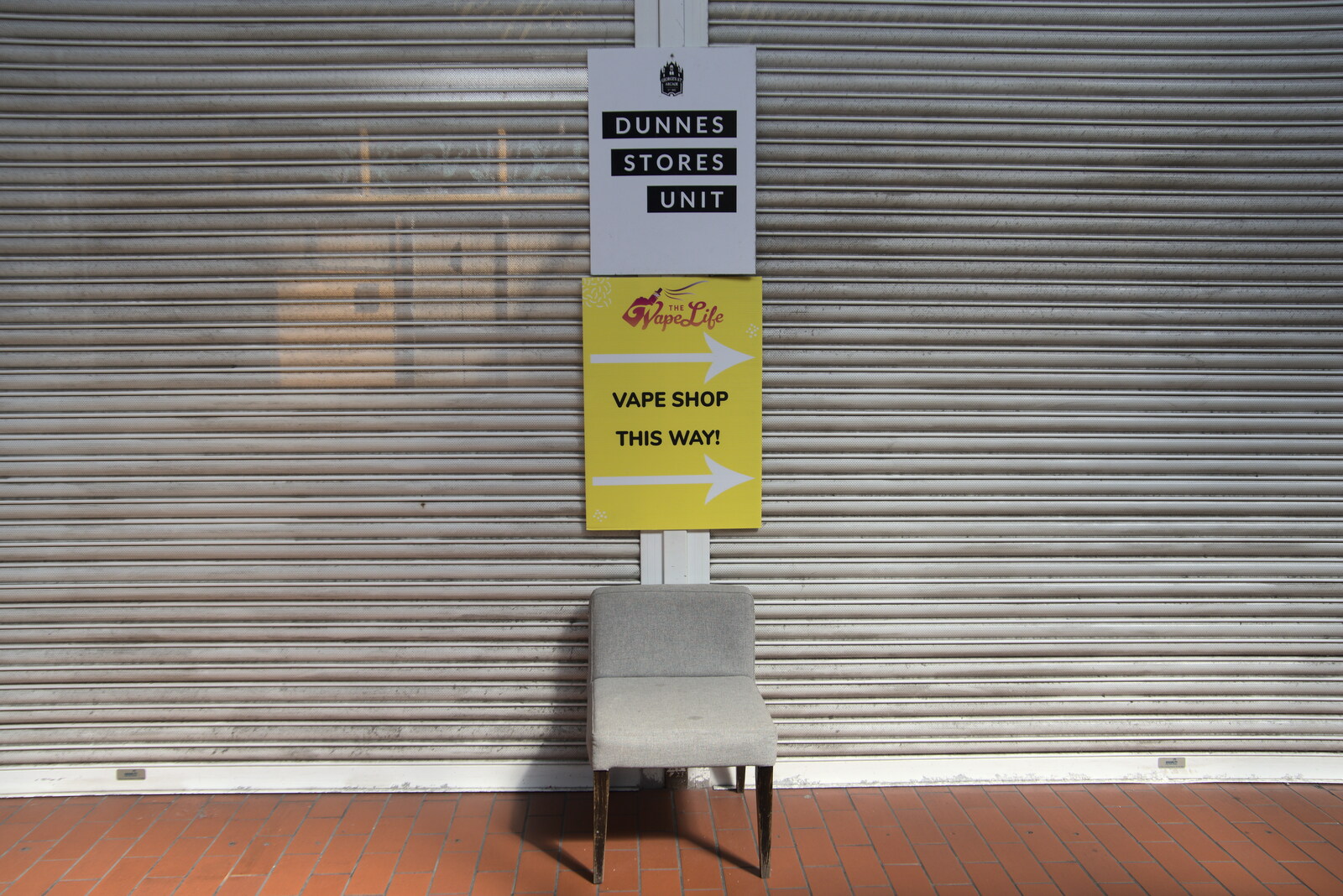 Blackrock North and South, Louth and County Dublin, Ireland - 23rd April 2022: A lonely chair and signs for a vape shop